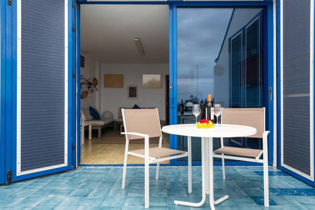 - une table et des chaises blanches sur la terrasse dans l'établissement Seaside Villa - Agaete, à Agaete