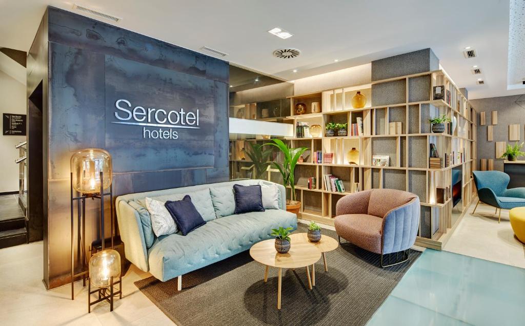 ein Wohnzimmer mit einem Sofa und einem Tisch in der Unterkunft Sercotel Ayala in Bilbao