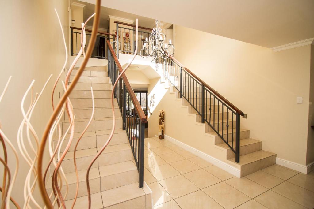a staircase in a home with a chandelier at Fernkloof Manor in Hermanus