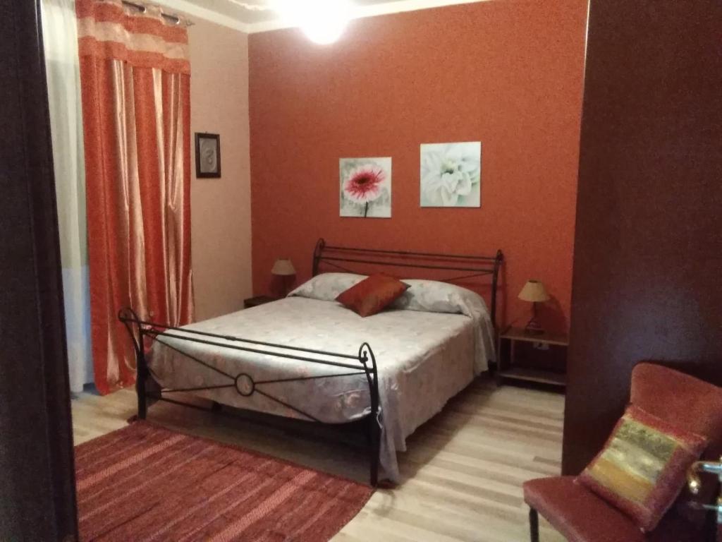 1 dormitorio con 1 cama y 1 silla en B&B "Al Calopinace" en Reggio Calabria