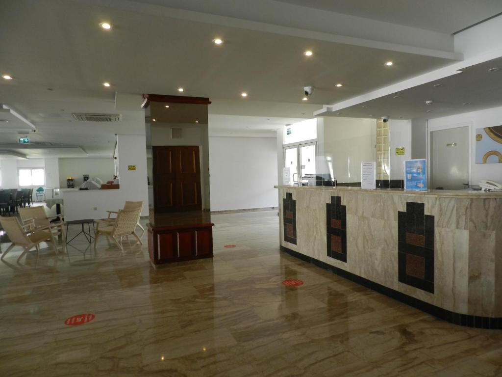 a lobby with a counter and a table and chairs at Evabelle Napa Hotel Apartments in Ayia Napa