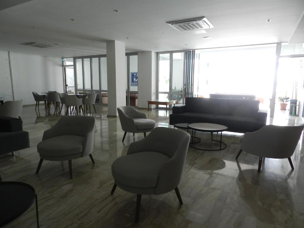 a waiting room with chairs and a piano at Evabelle Napa Hotel Apartments in Ayia Napa
