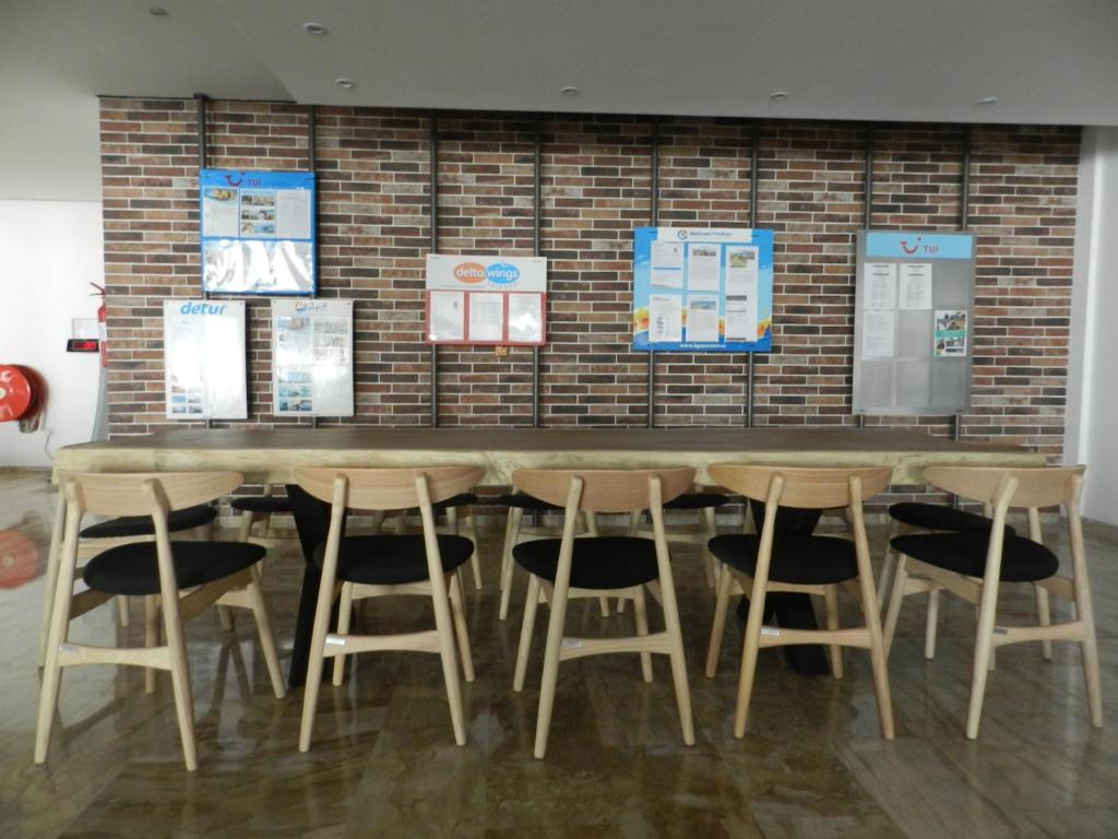a table with chairs and posters on a brick wall at Evabelle Napa Hotel Apartments in Ayia Napa