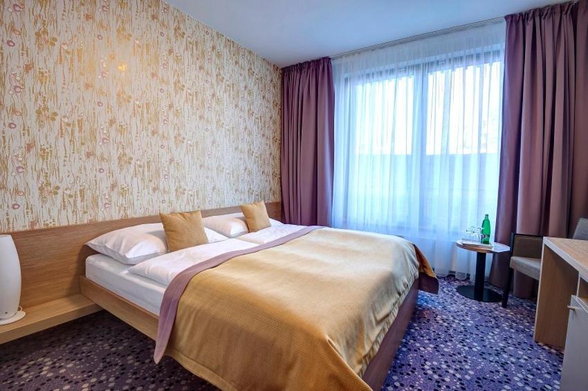Postel nebo postele na pokoji v ubytování Hotel Vinice Hnanice