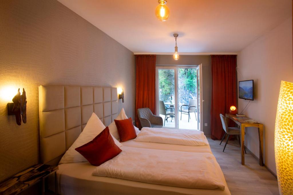 a hotel room with two beds and a balcony at Bad Emser Hof in Bad Ems