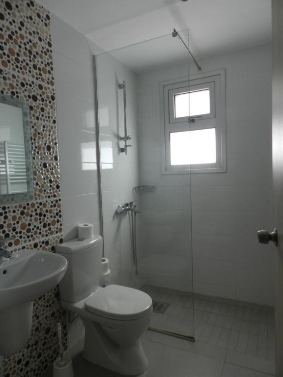a bathroom with a shower and a toilet and a sink at Evabelle Napa Hotel Apartments in Ayia Napa
