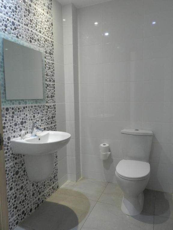 a bathroom with a white toilet and a sink at Evabelle Napa Hotel Apartments in Ayia Napa