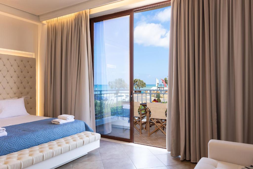 a bedroom with a bed and a balcony at Kahlua Bay Apartments in Hersonissos