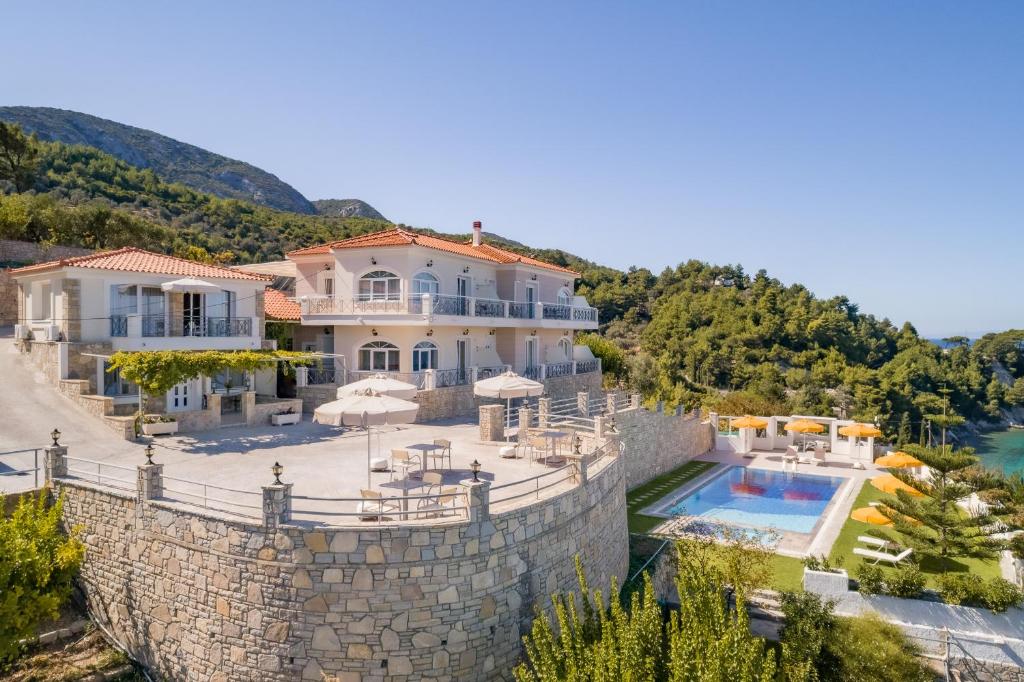 a villa on the edge of a wall with a swimming pool at PENNY LUXURY APARTMENTS in Kokkari