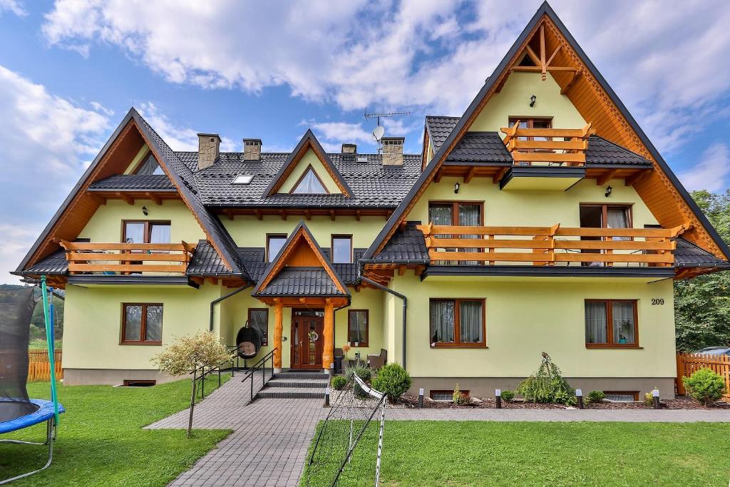 a large house with a gambrel roof at Słoneczny Dworek in Białka Tatrzańska