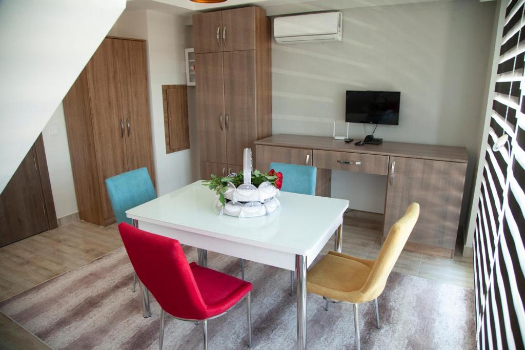 a dining room with a white table and red chairs at The Era Otel in Gölhisar