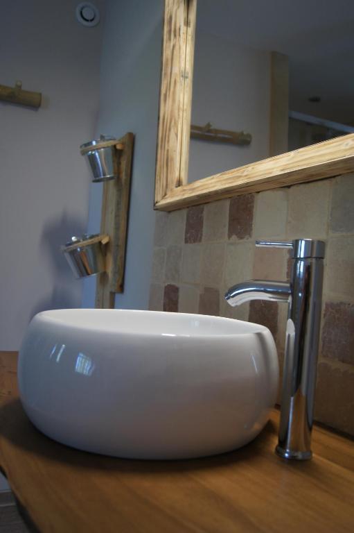 lavabo blanco en una encimera de madera en el baño en L’Antre d’Eux, en Carcassonne