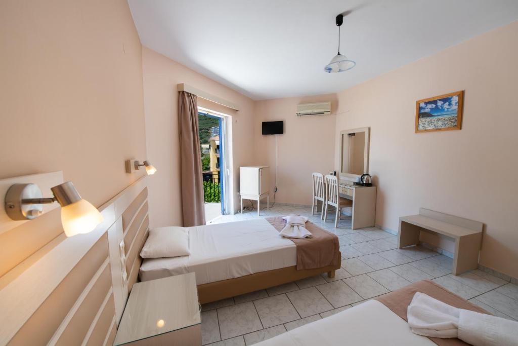 a bedroom with a bed and a desk in a room at Surf Hotel in Vasiliki