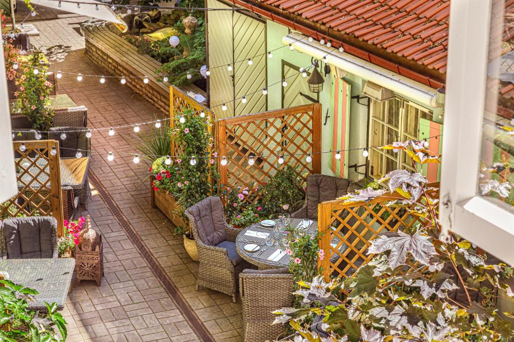 un patio con mesa, sillas y plantas en Schlössle Hotel - The Leading Hotels of the World en Tallin