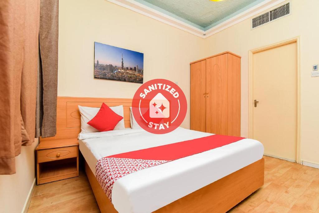 a bedroom with a bed with a red sign on it at Sama Hotel in Sharjah