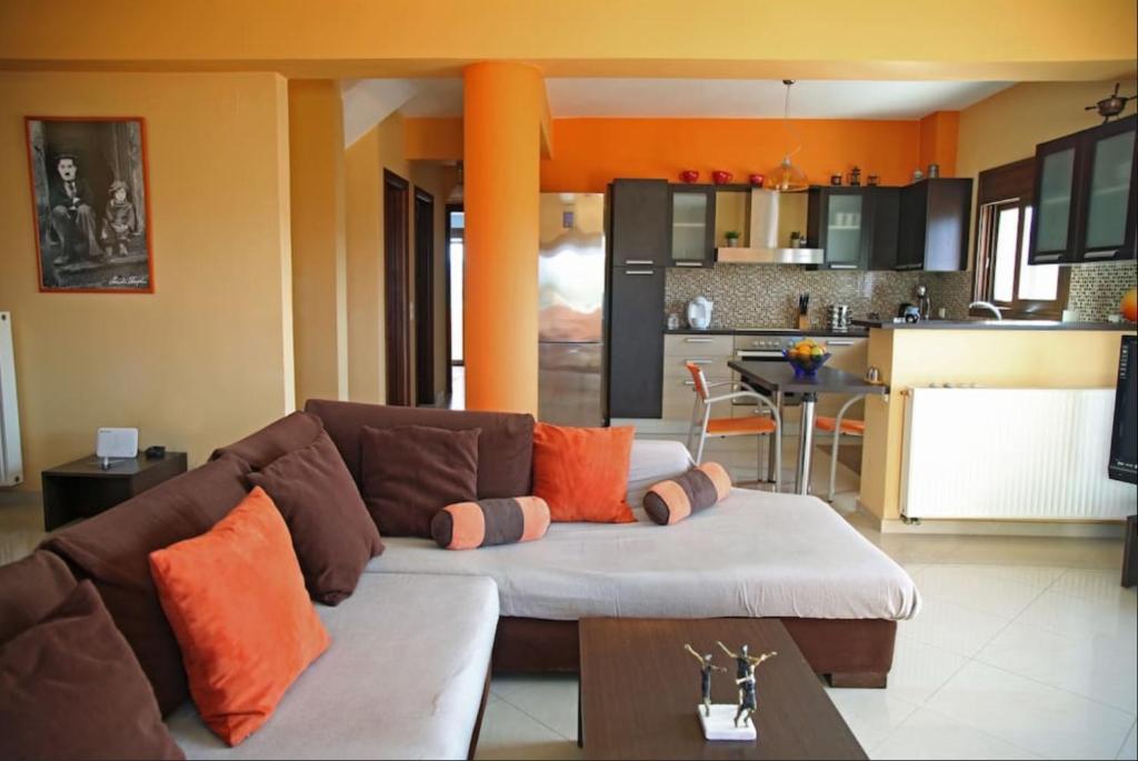 uma sala de estar com um sofá e uma cozinha em George’s Home em Sitia