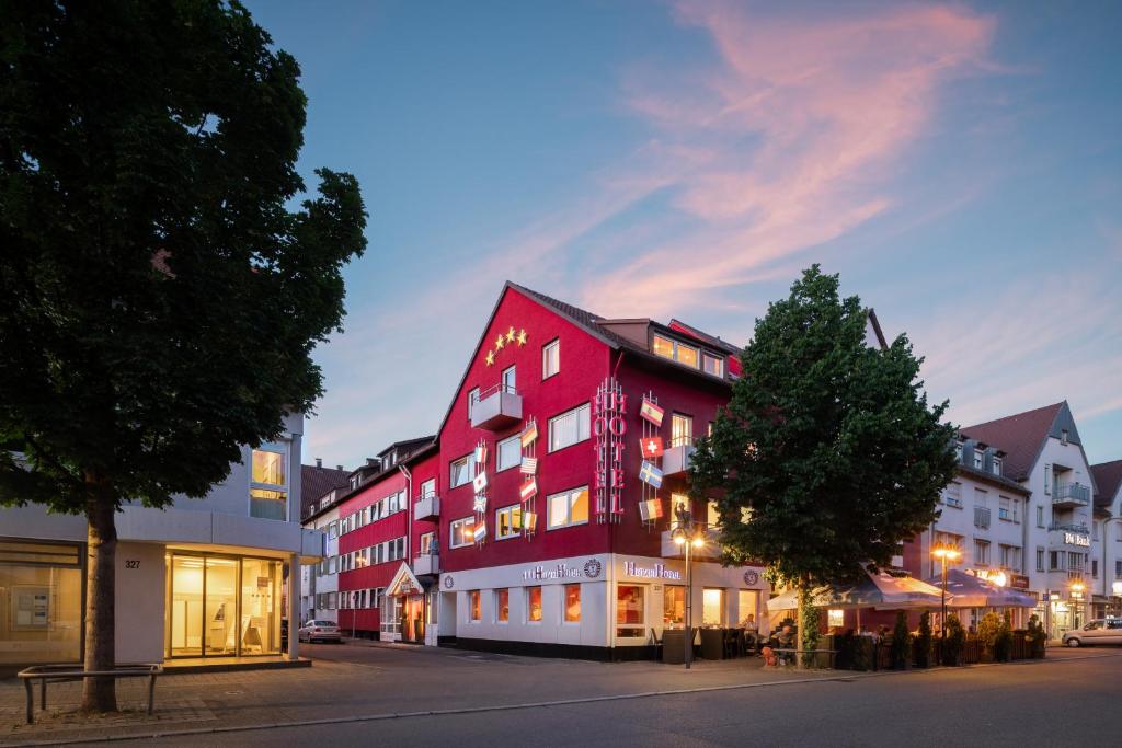 a large red building on the side of a street at Hetzel Hotel Stuttgart in Stuttgart