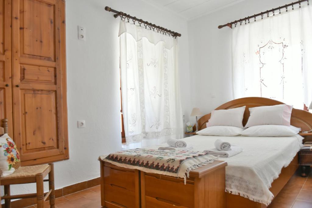 a bedroom with a large bed with a wooden headboard at Grandmas Guest House in Hydra