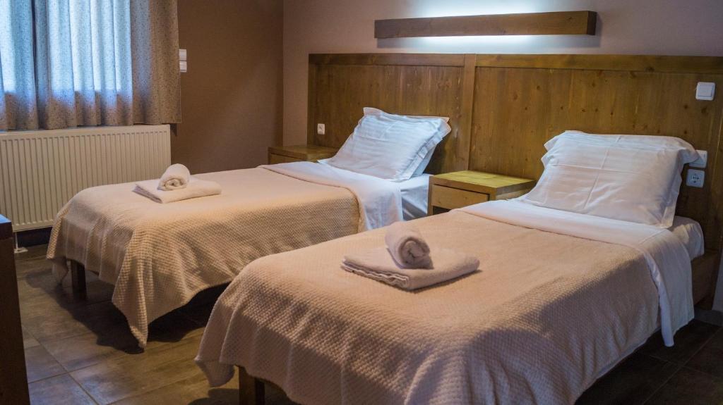 Una habitación de hotel con dos camas con toallas. en Kedros Chalet, en Áyios Dhimítrios