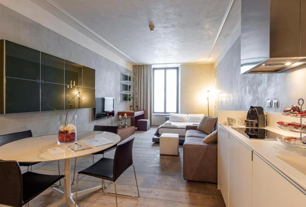 cocina y sala de estar con mesa y sofá en Milan Royal Suites - Centro Duomo, en Milán