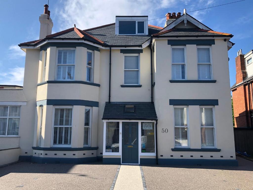 a white house with a blue door on a street at Hotel 50 in Bournemouth