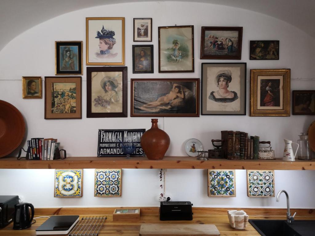 a room with a shelf with pictures on the wall at Casa do Sertório - Casa inteira in Évora
