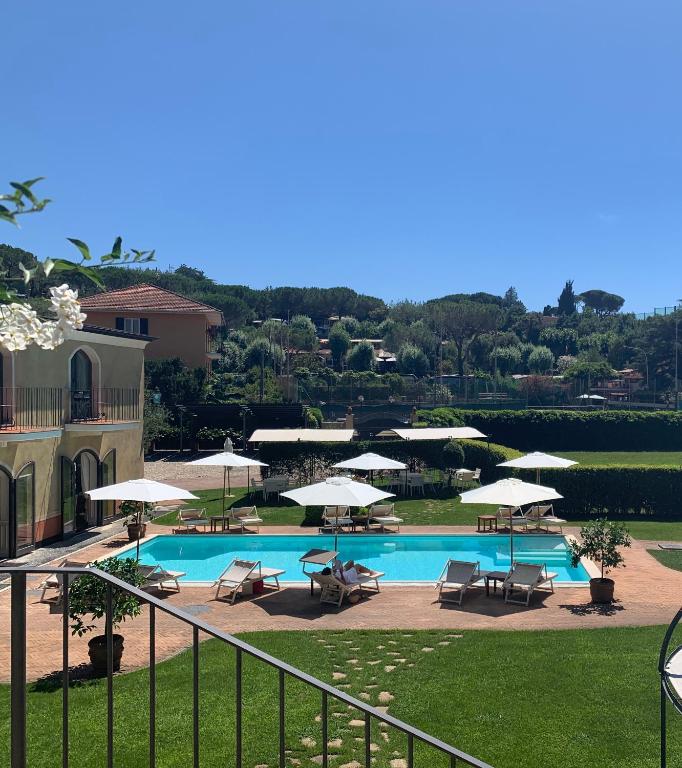 a swimming pool with chairs and umbrellas at Villa Agnese in Sestri Levante