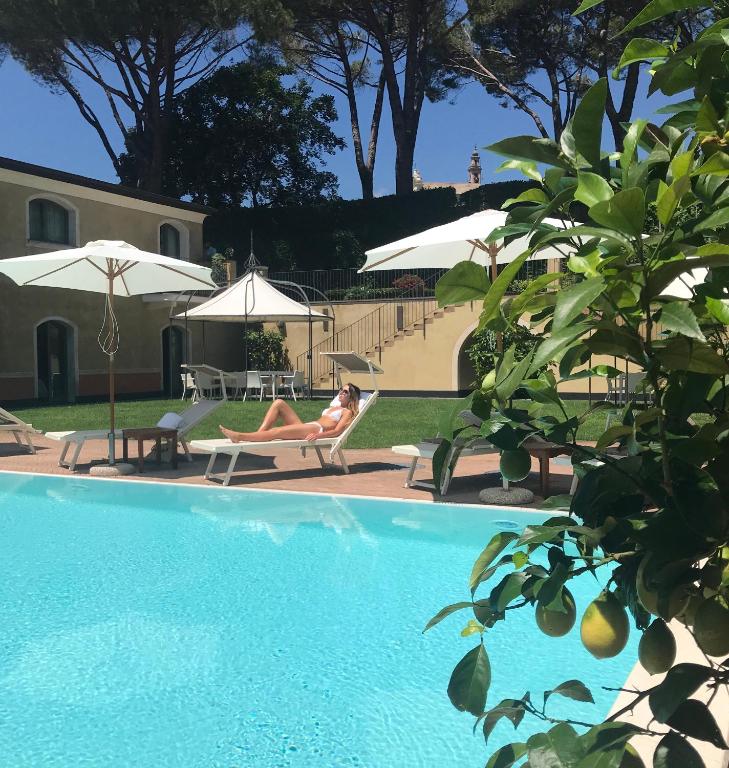 a woman laying on a chair next to a swimming pool at Villa Agnese in Sestri Levante