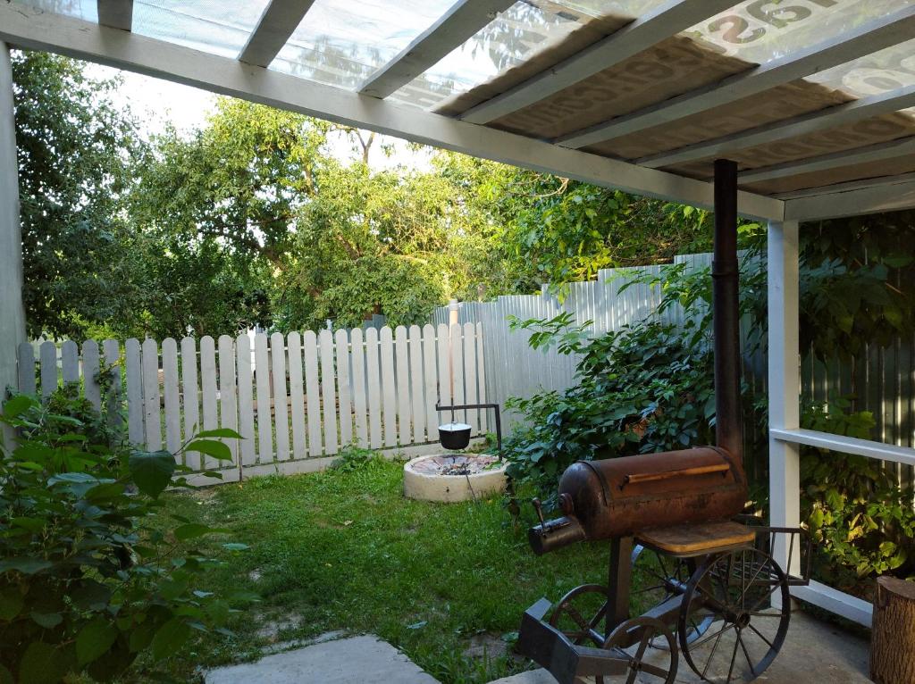 een achtertuin met een wit hek en een oud object bij Дом с баней для отпуска in Nyzhni Mlyny