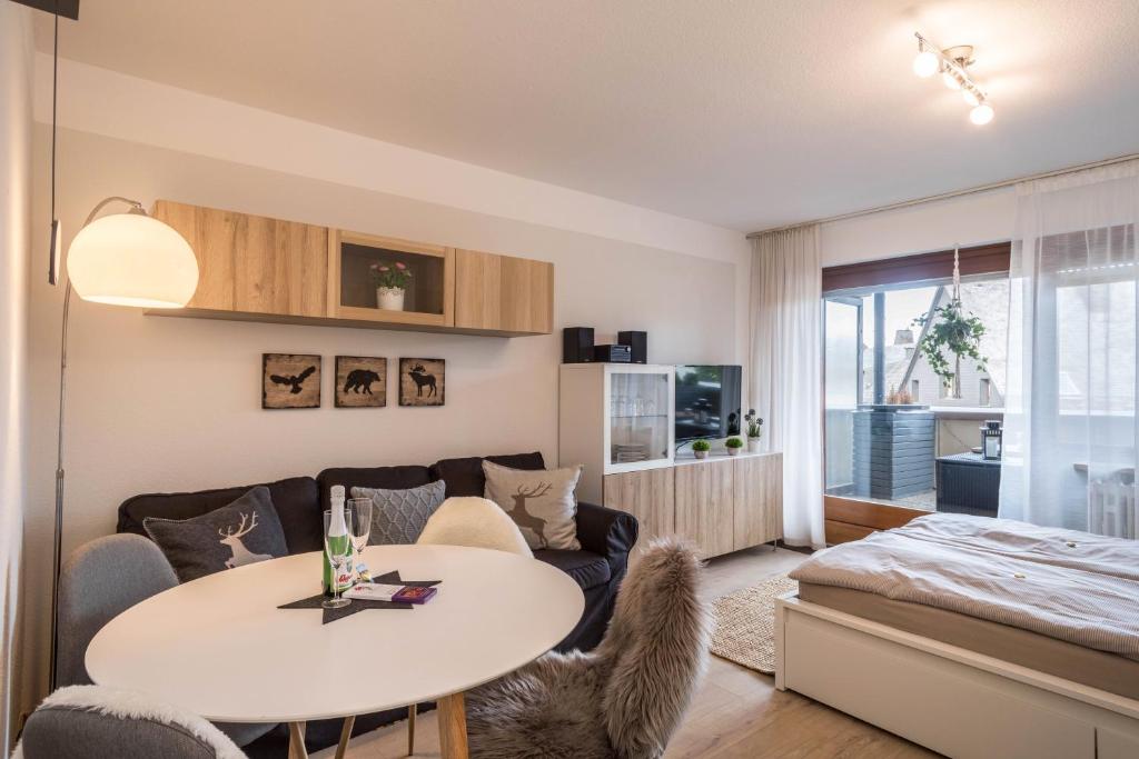 ein Wohnzimmer mit einem Tisch und einem Sofa in der Unterkunft Heimelig im Hirschen App 118 in Schönwald