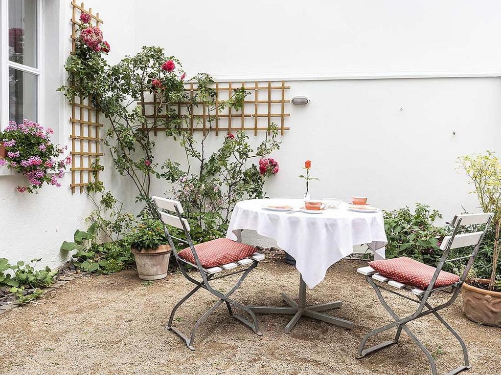 una mesa y dos sillas frente a una casa blanca en Hotel Aigner, en Bonn