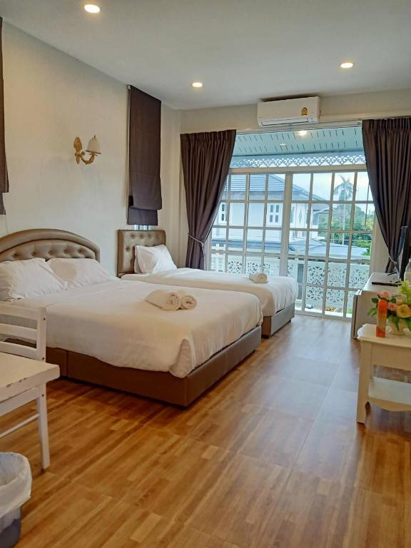 a hotel room with two beds and a balcony at Promporn Boutique Hotel in Nan