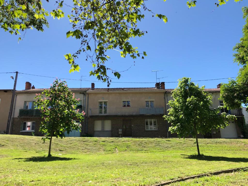 an old building with two trees in front of it at Jaures Home in Carmaux