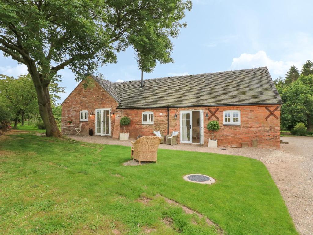 an old brick house with a grass yard at Barn Owl in Ashbourne