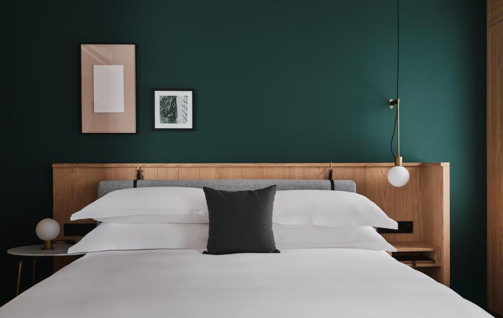 a bedroom with a white bed and a green wall at Kimpton Da An Taipei- an IHG Hotel in Taipei