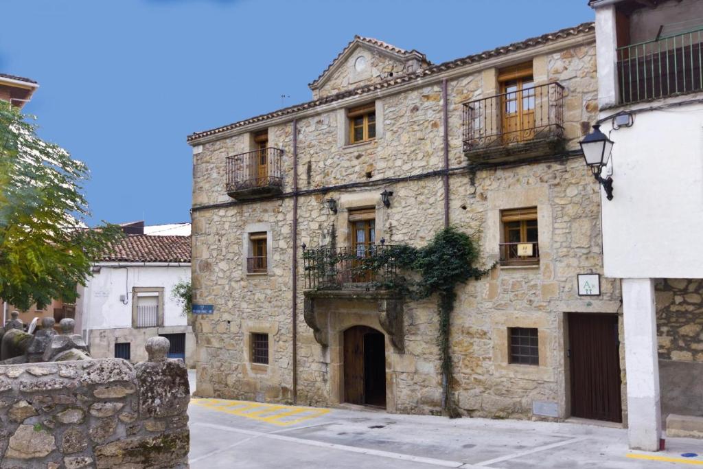 an old stone building with balconies on a street at El Padre La Calle in El Torno