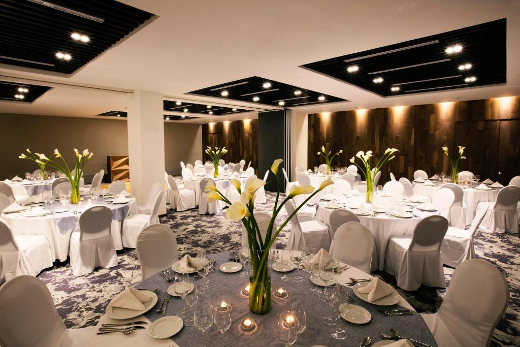 A formally arranged banquet dining room with round tables and floral centerpieces.