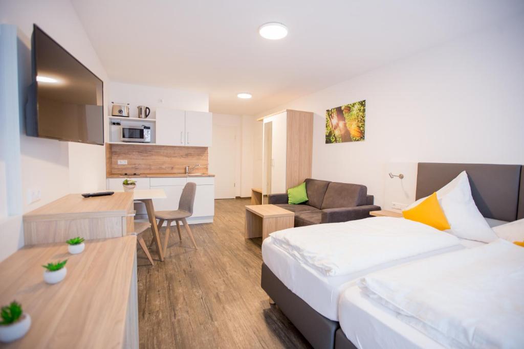 a hotel room with a bed and a kitchen at Schoko Apartments in Unterschneidheim
