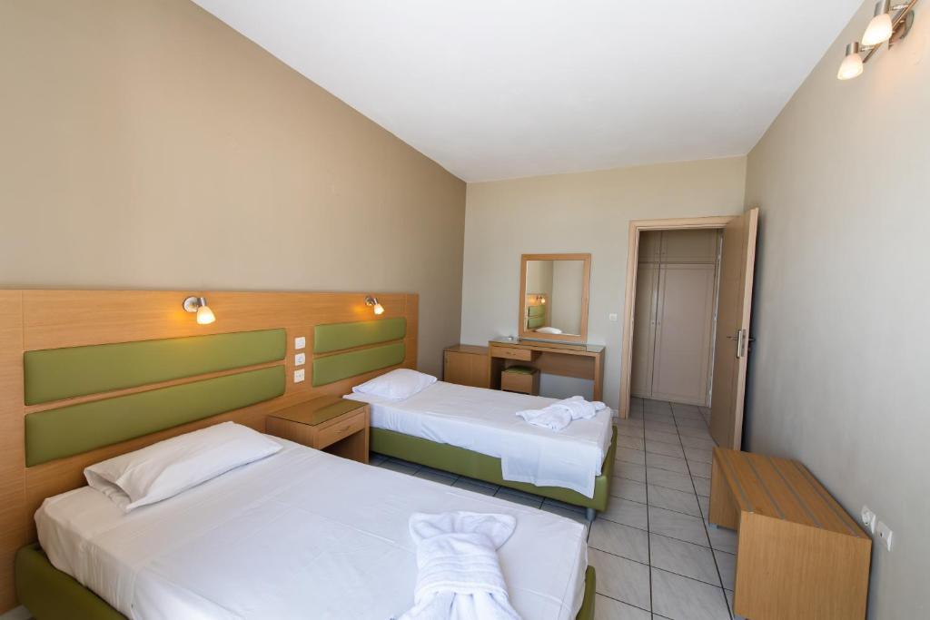 a hotel room with two beds and a mirror at Surf Hotel in Vasiliki