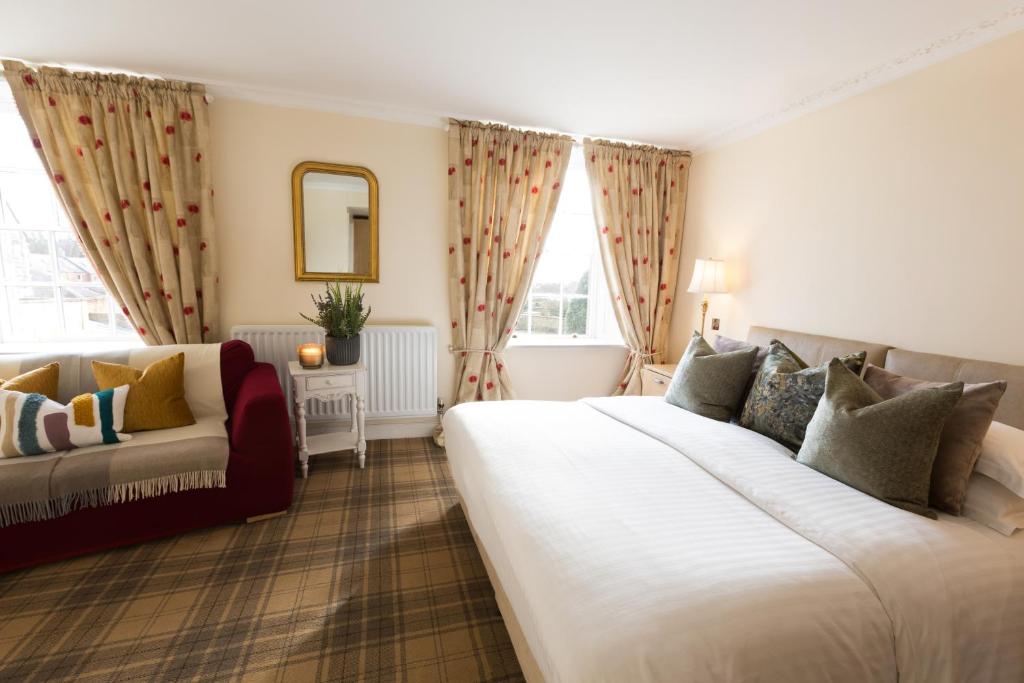 a hotel room with two beds and a couch at Warkworth House Hotel in Warkworth
