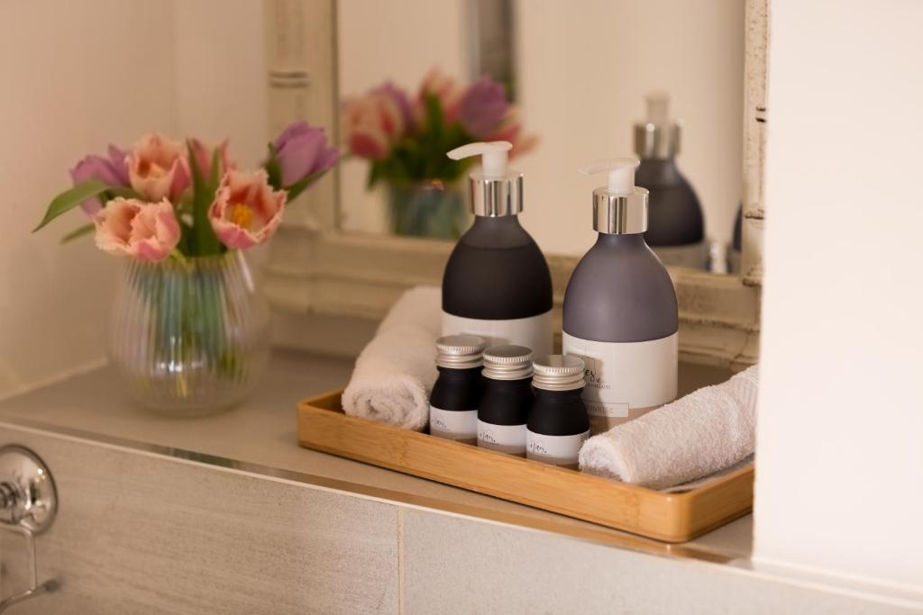 a bathroom counter with two bottles of soap and flowers at Warkworth House Hotel in Warkworth