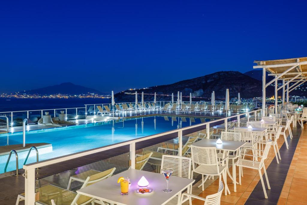 una fila di tavoli e sedie su una nave da crociera di notte di Art Hotel Gran Paradiso a Sorrento