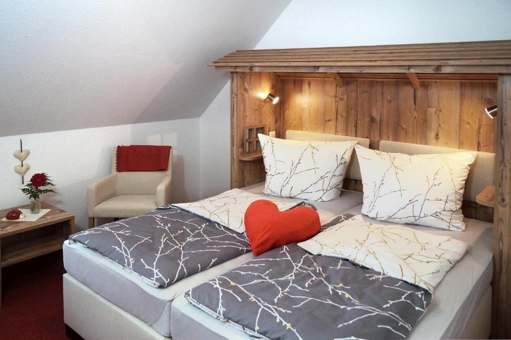 ein Schlafzimmer mit einem Bett mit einem roten Herz darauf in der Unterkunft Erzgebirgshotel Misnia Bärenfels in Kurort Altenberg