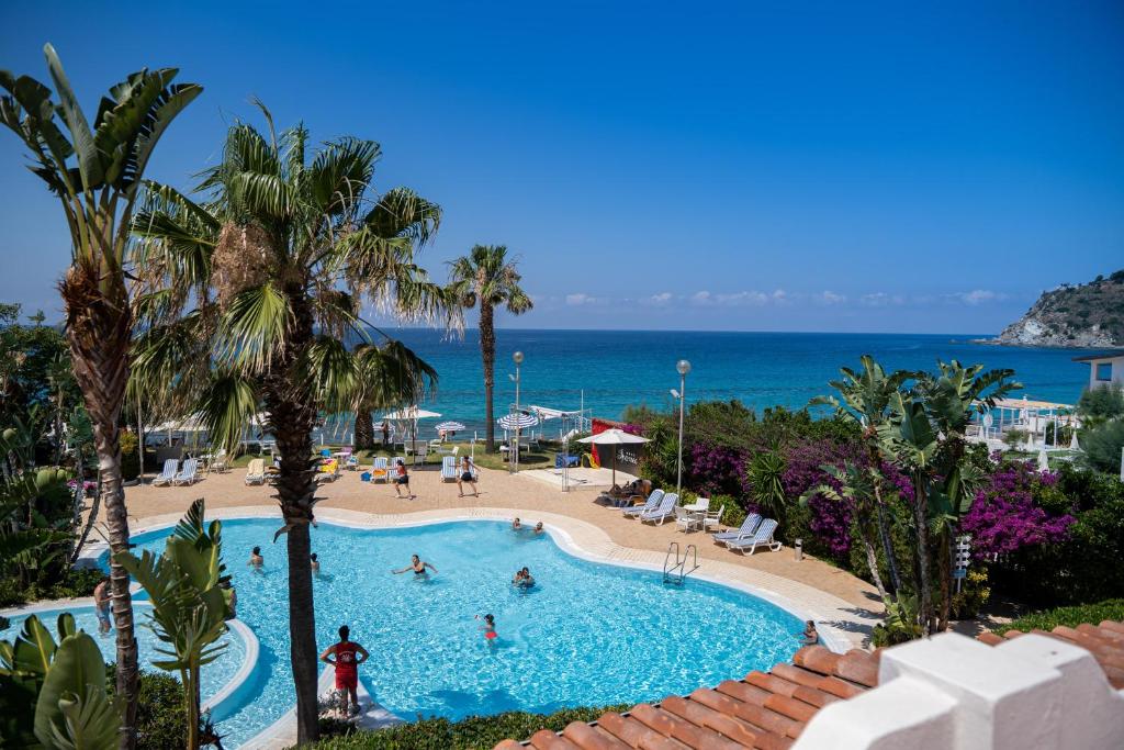 a view of a swimming pool and the beach at Hotel Ipomea Club in Capo Vaticano