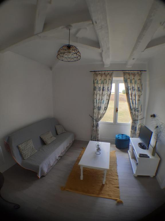 a living room with a couch and a table at Beautiful pigeonnier with sensational surroundings in Pujols