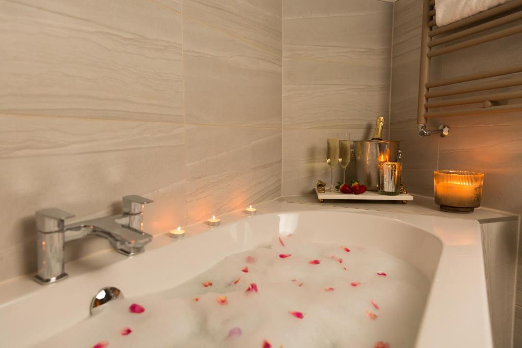 a bathroom with a bath tub with flowers on it at Warkworth House Hotel in Warkworth