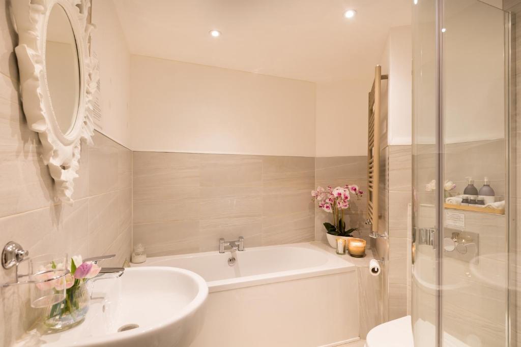 a white bathroom with a tub and a sink at Warkworth House Hotel in Warkworth