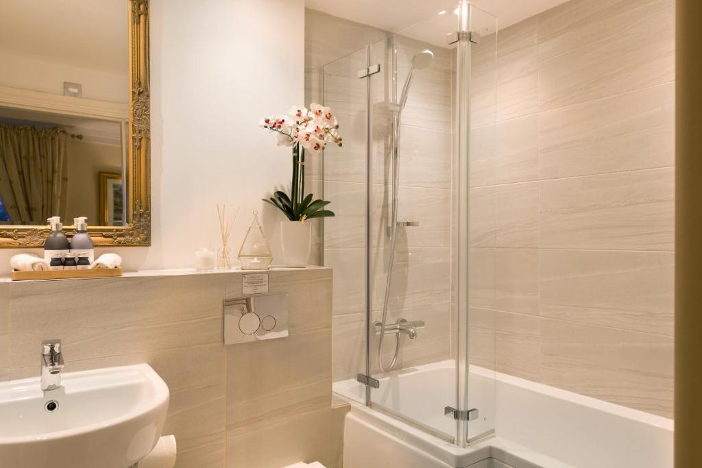 a bathroom with a shower and a toilet and a sink at Warkworth House Hotel in Warkworth