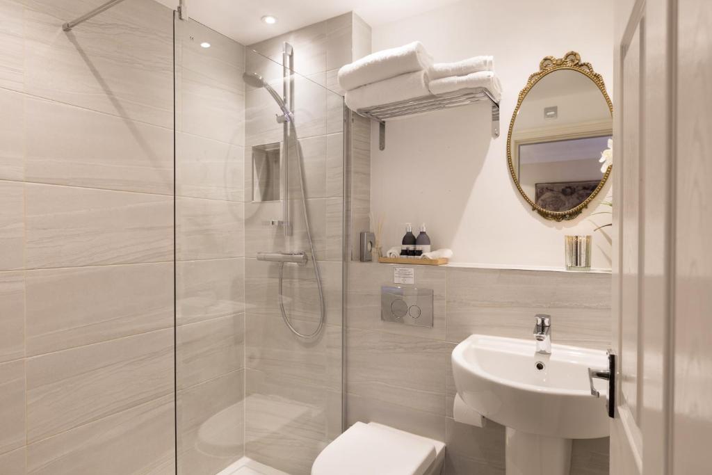 a bathroom with a shower and a toilet and a sink at Warkworth House Hotel in Warkworth