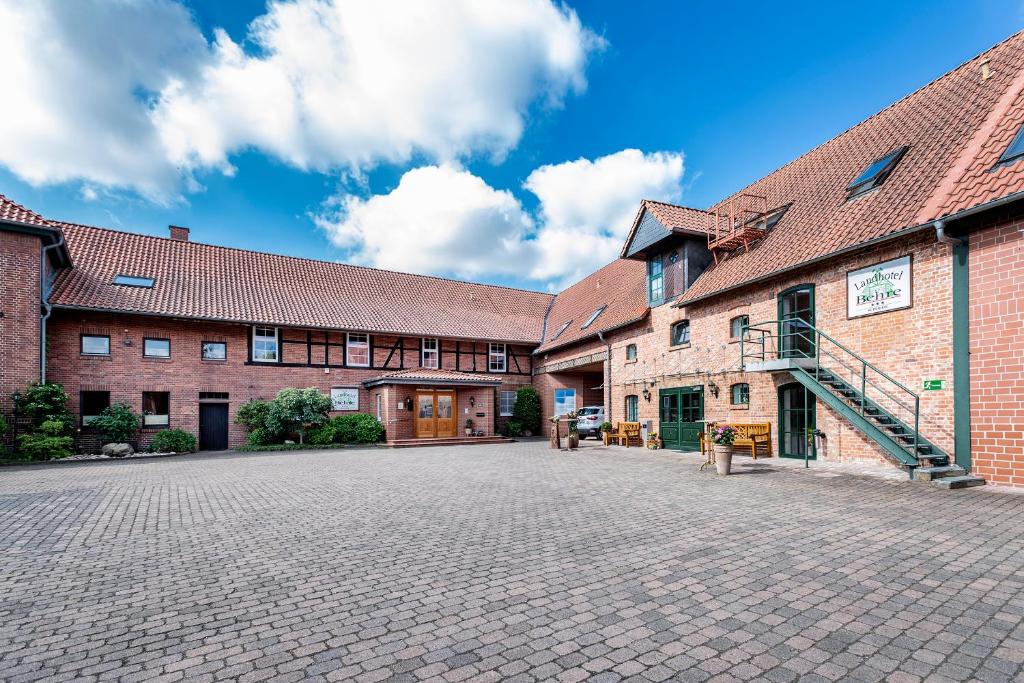 a cobblestone street in front of two brick buildings at Landhotel Behre in Lehrte